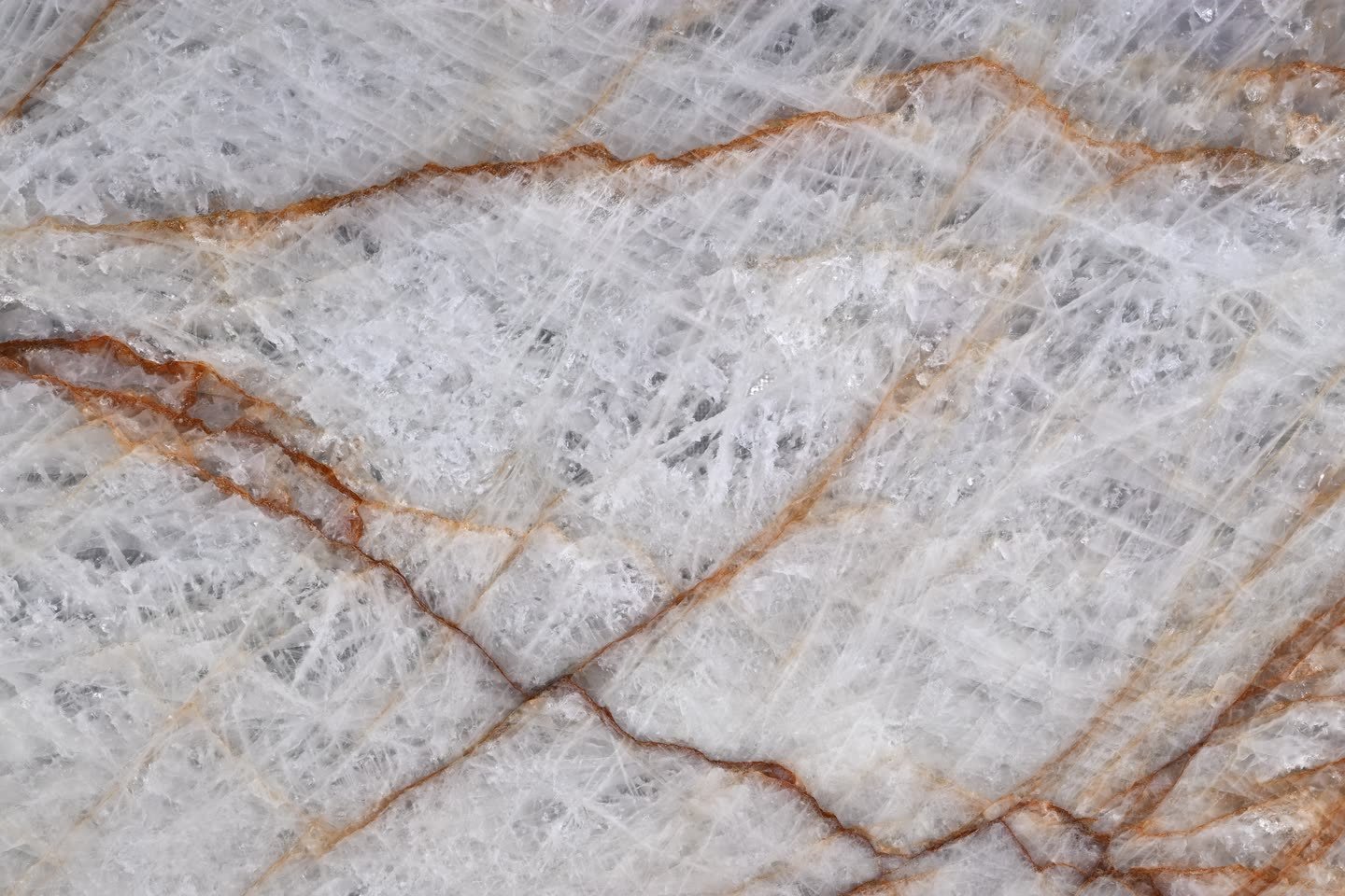 Rosso Crystallo — close view of the stone surface. White crystal crossed by rust-red and amber veining.