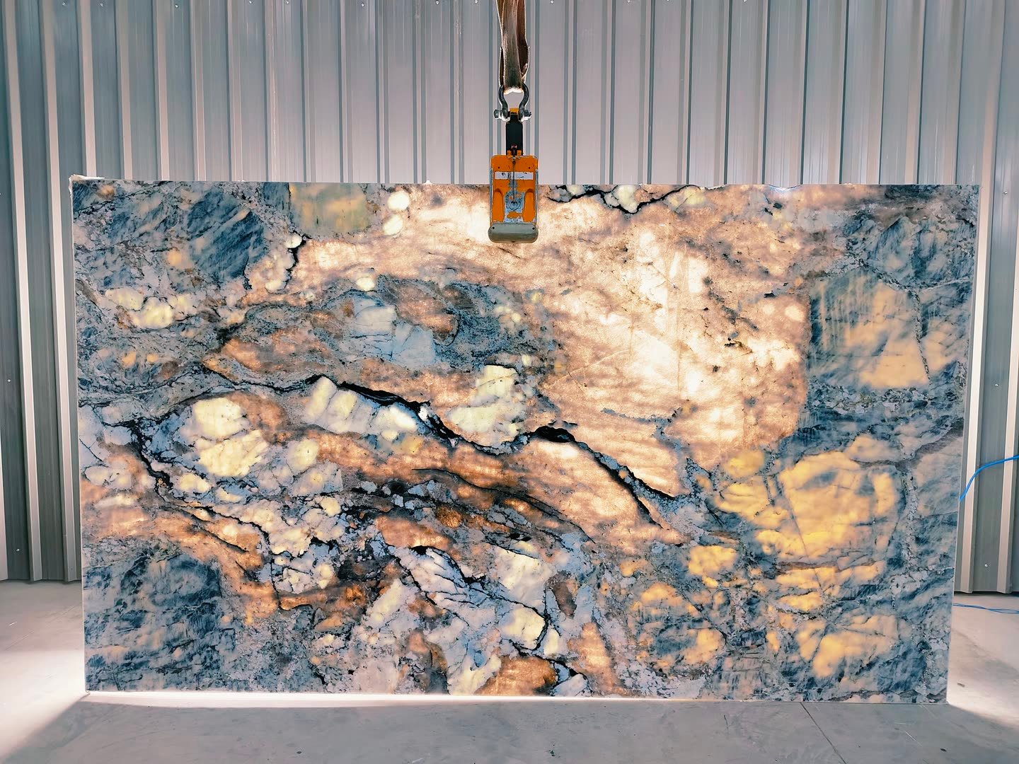 Blue Alpine — the slab lit from behind so the translucency and vein structure read through the stone.