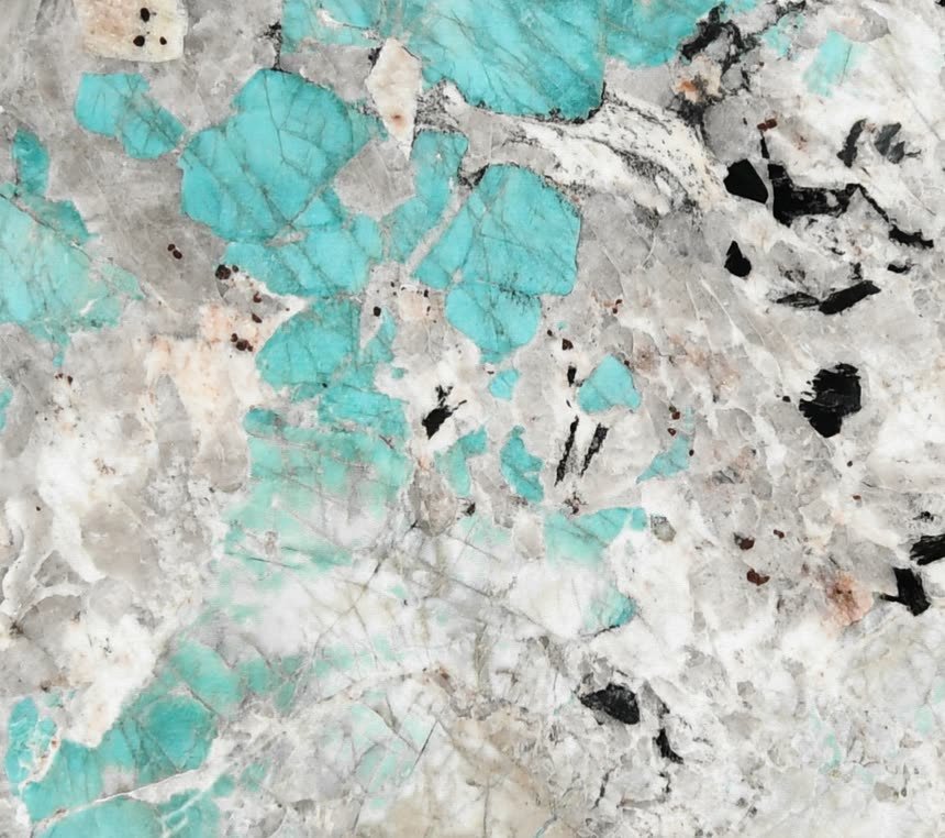 Amazonite — close view of the stone surface. Turquoise crystal fields set into white quartz and black mineral.