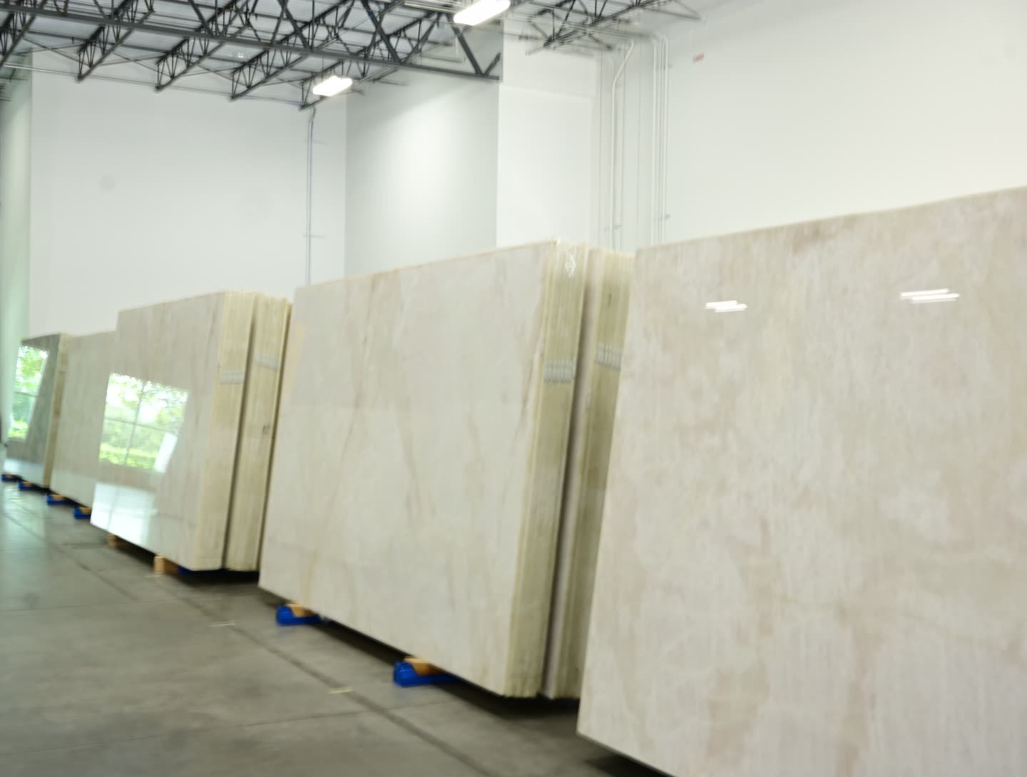 Stone slabs with grey and cream veining standing in a row on the showroom floor.